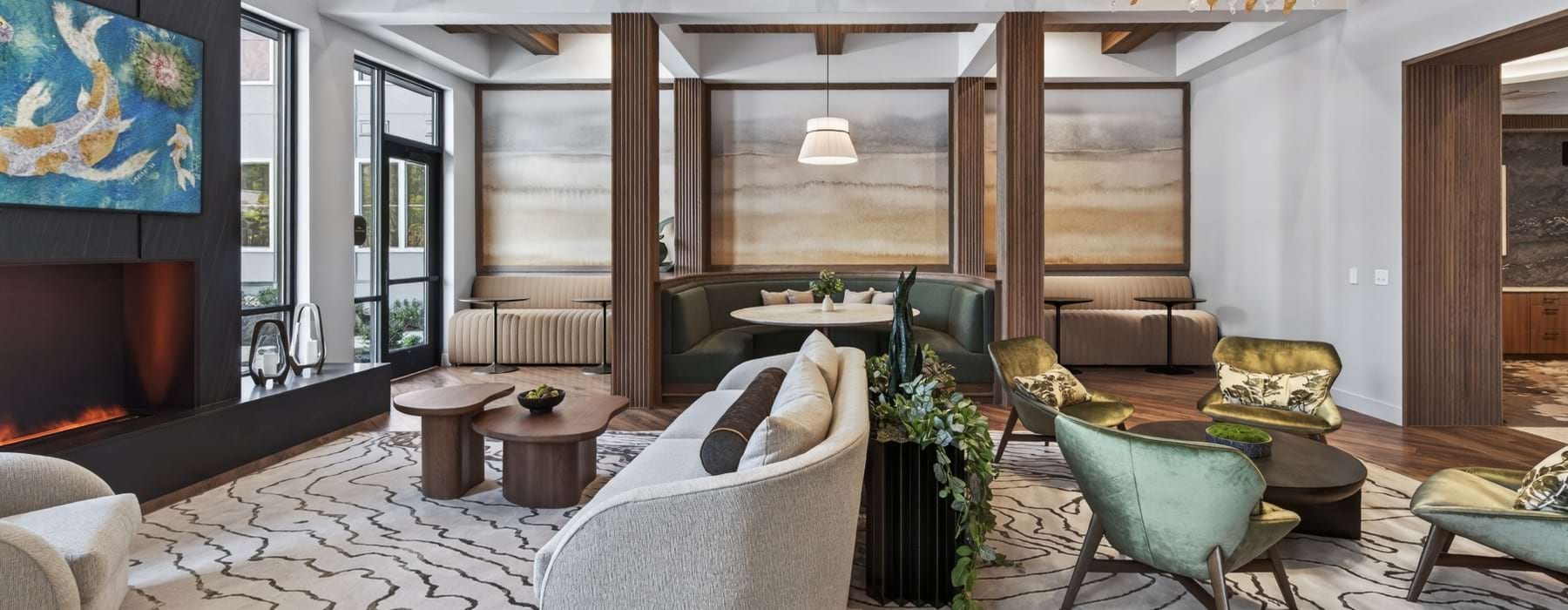 Clubroom with couch  and chair seating a fire place,  dining table, banquettes, and tables.